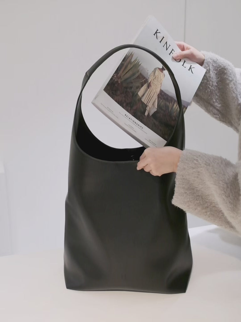 Lightweight commuter laptop bag attached to a suitcase using a hidden luggage sleeve.